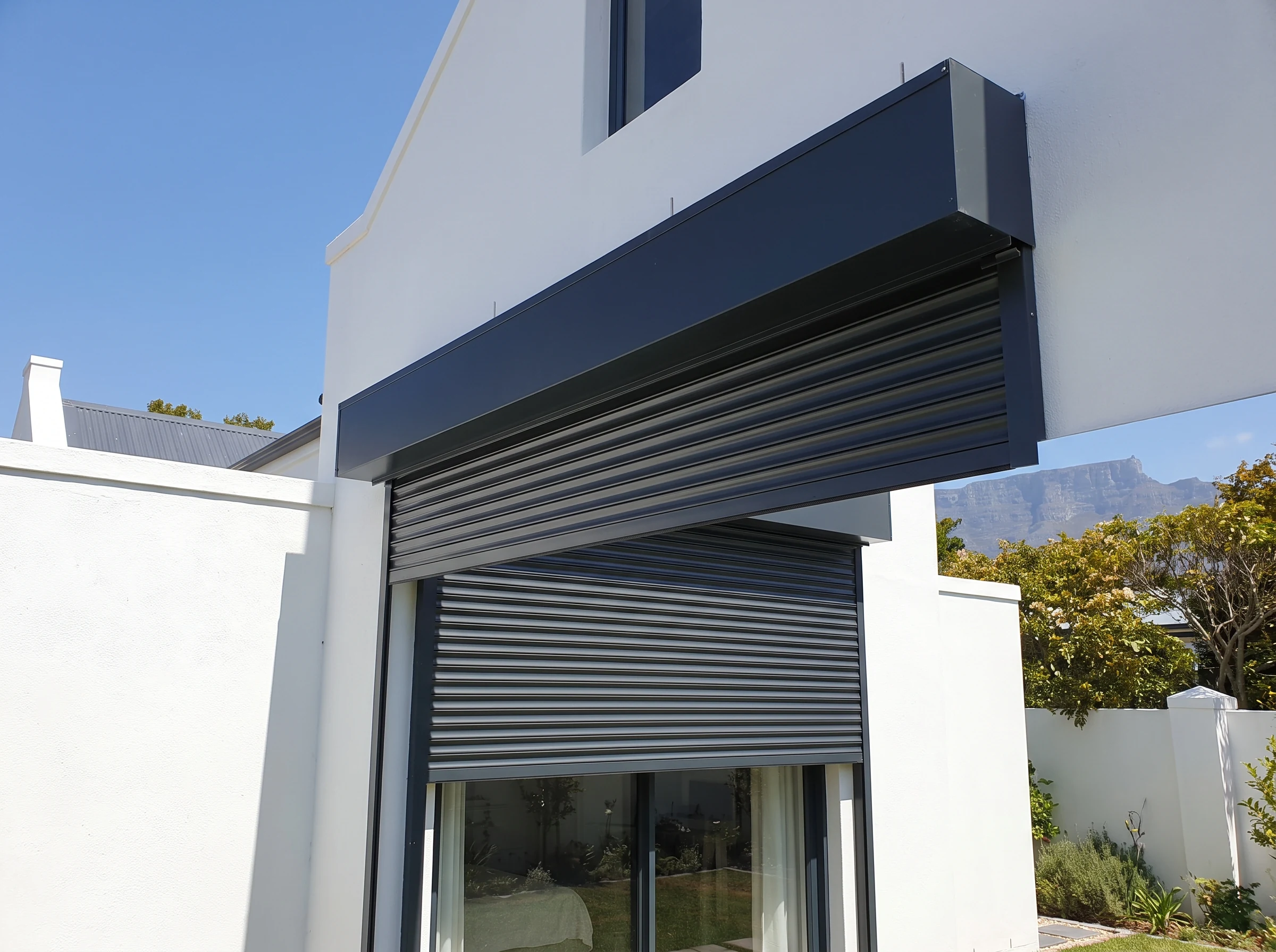External aluminium roller shutter partly lowered from a headbox outside a Rondebosch window
